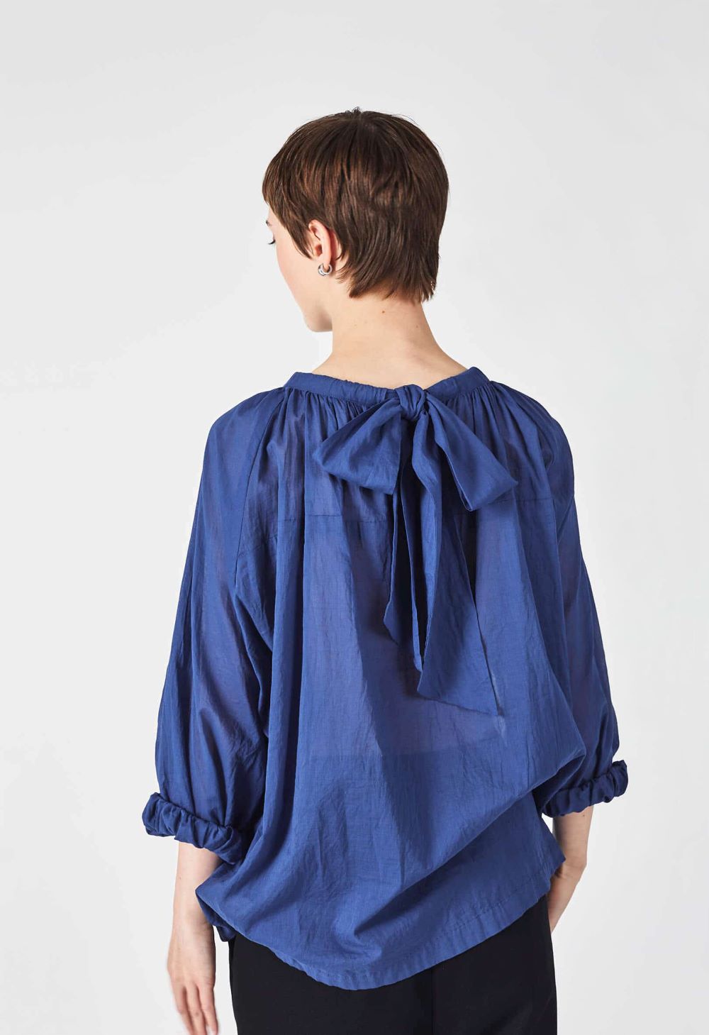 woman wearing a romantic, feminine,  blue, handmade, gathered frilled, puffed sleeve, pussy bow cotton top
