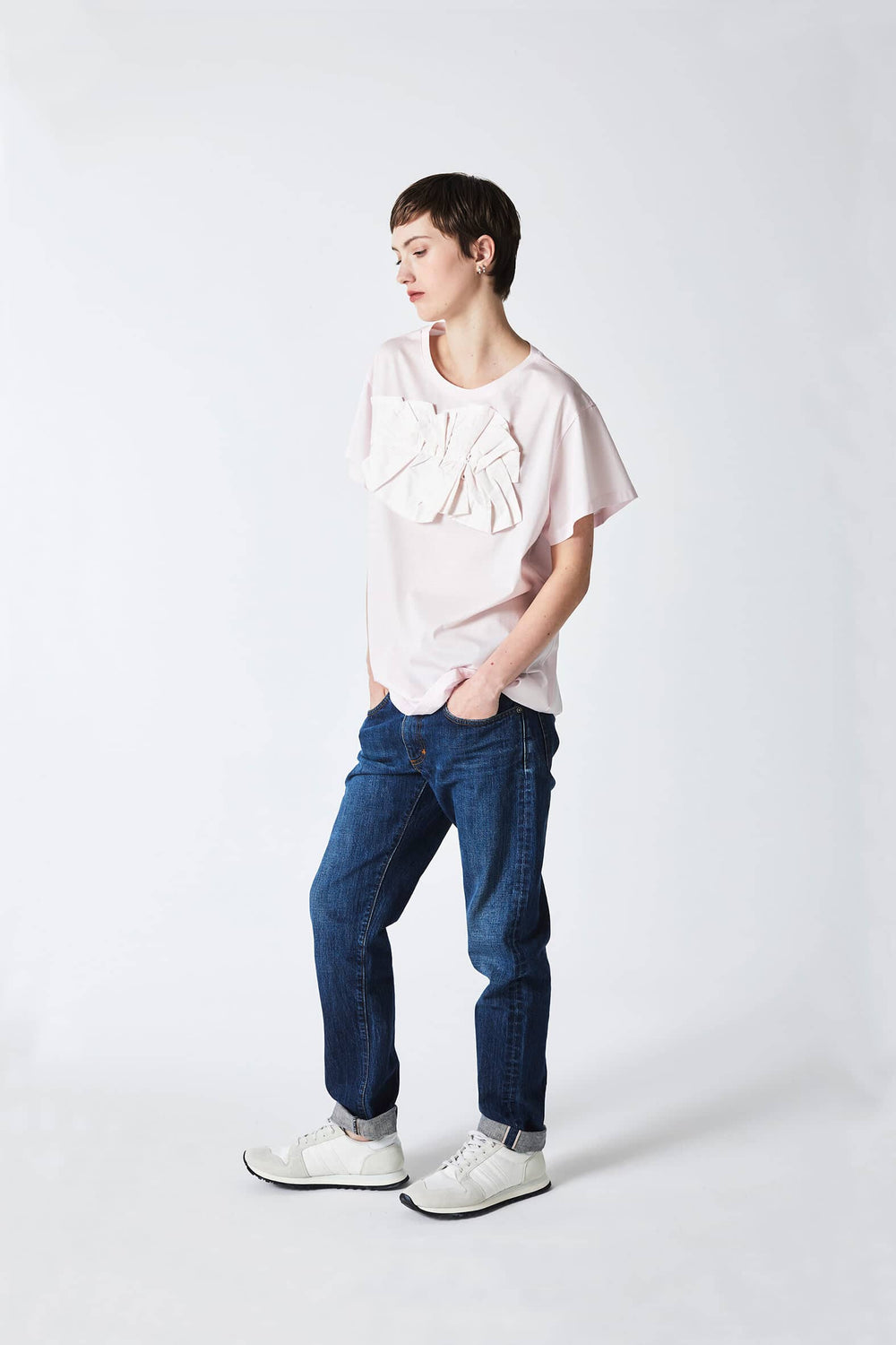 woman wearing pale pink, short sleeved, handmade, origami top, original artistic design