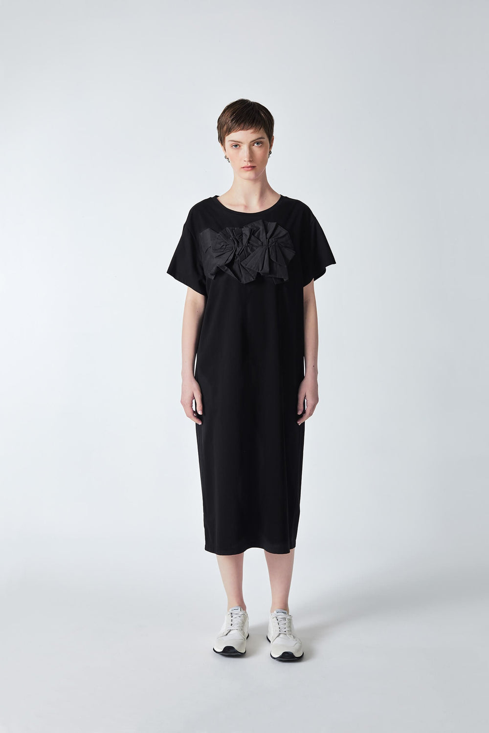 woman wearing black, handmade, origami dress, with original artistic design in cotton knit
