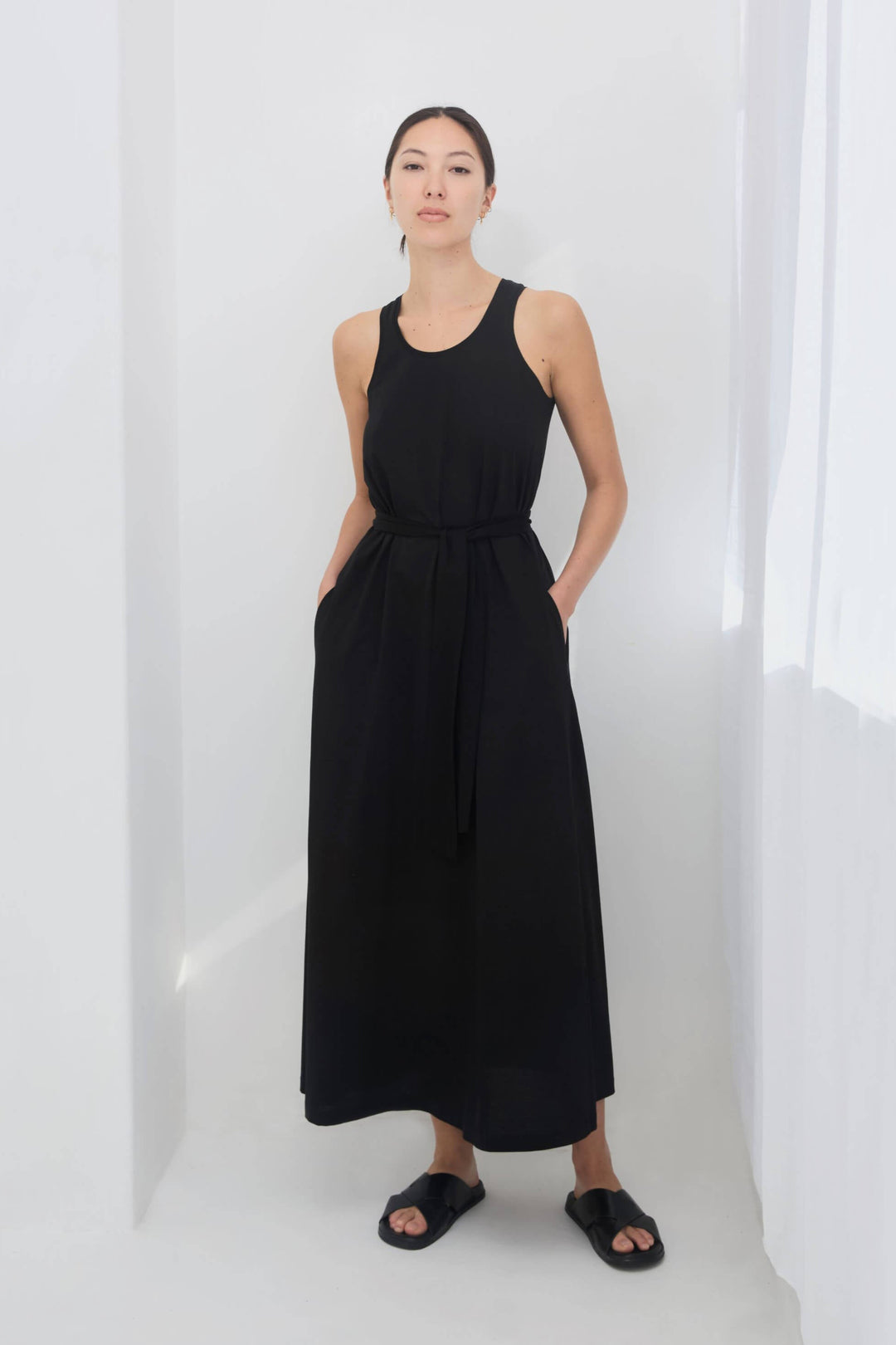 woman wearing a black sleeveless racer back singlet maxi dress