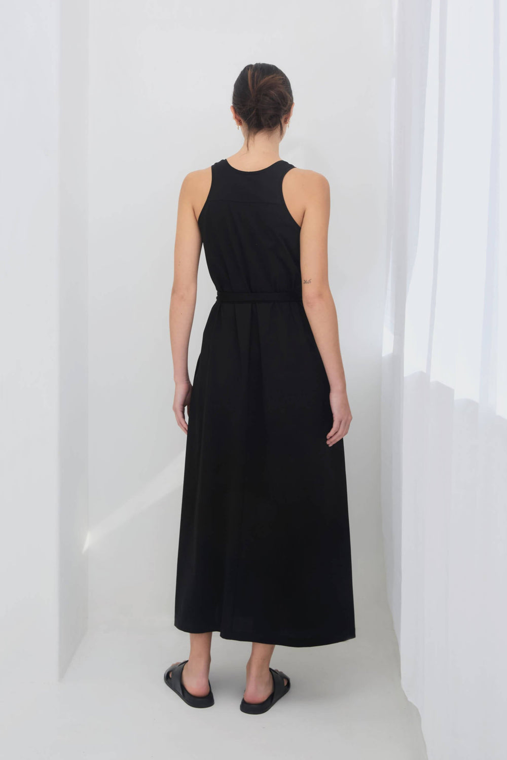 woman wearing a black sleeveless racer back singlet maxi dress