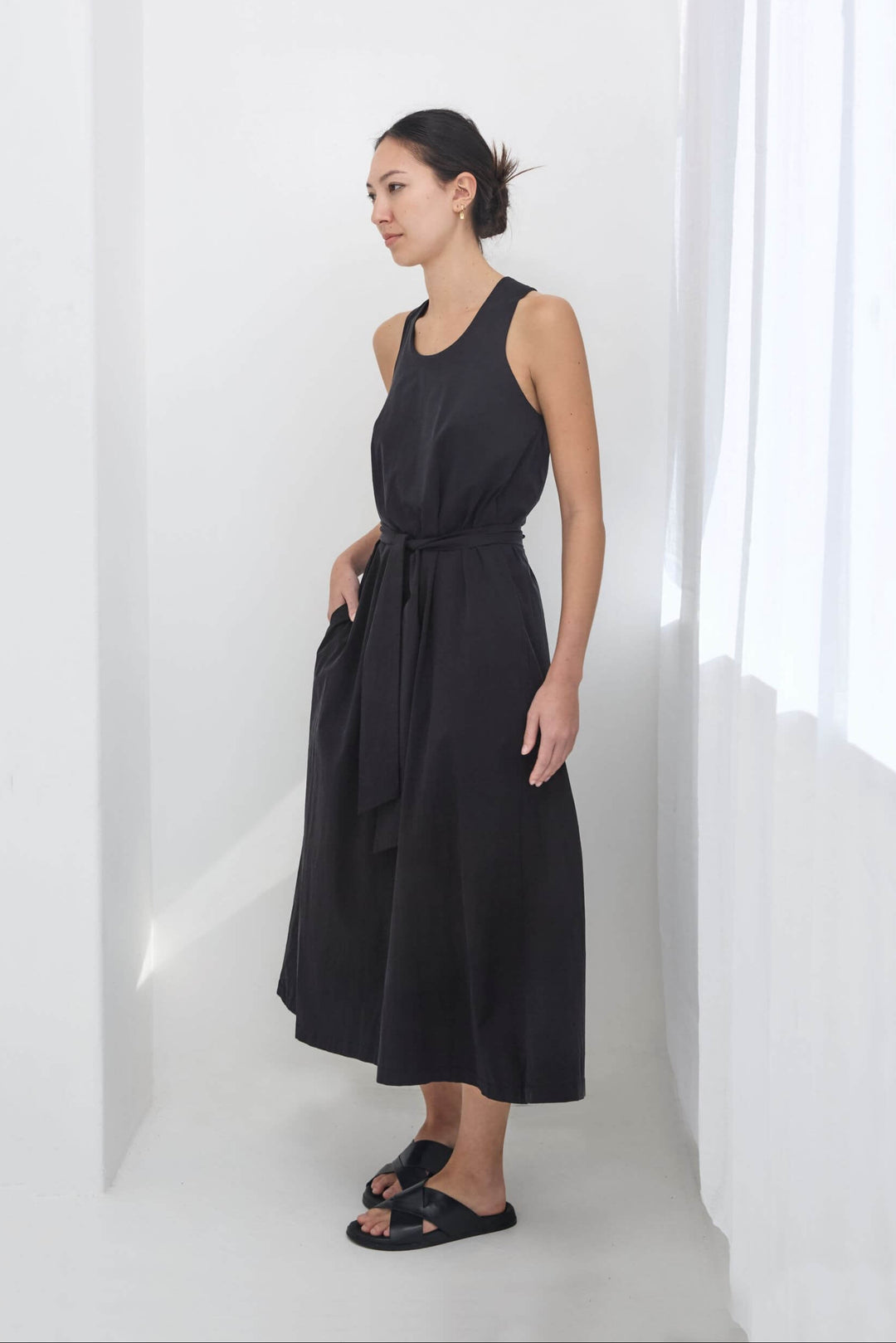 woman wearing a black, handmade, japanese, cross over strap, cotton maxi dress