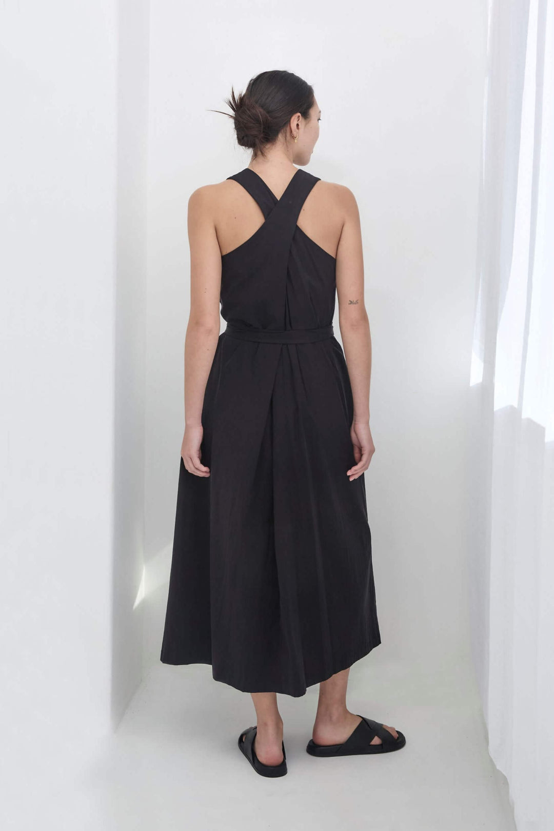 woman wearing a black, handmade, japanese, cross over strap, cotton maxi dress
