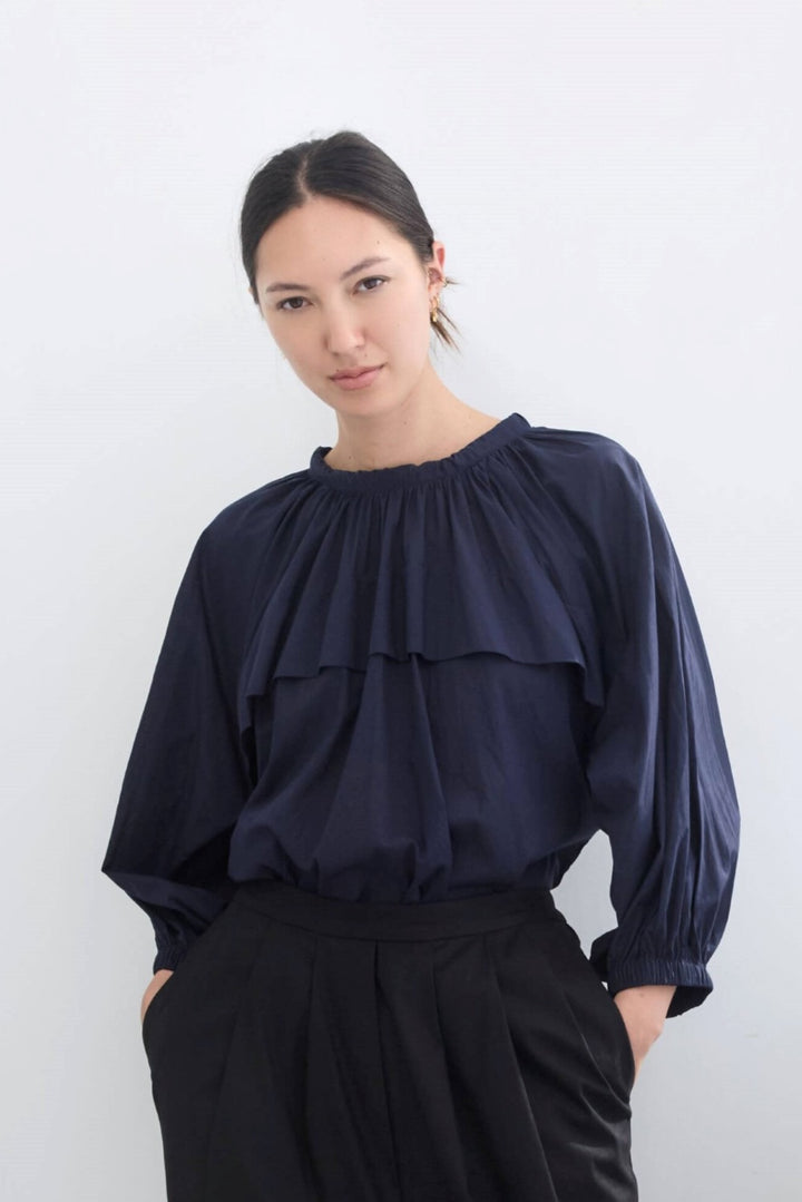 woman wearing a romantic, feminine,  navy, handmade, gathered frilled, puffed sleeve, pussy bow cotton top
