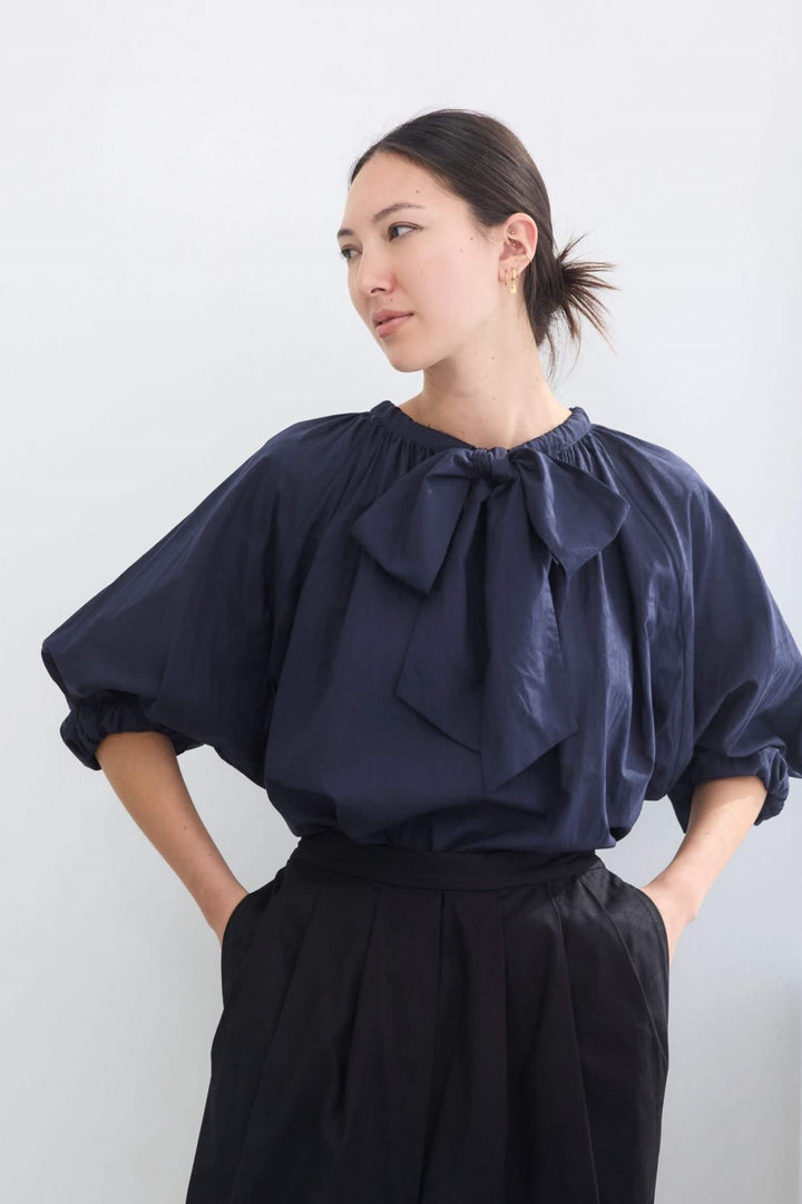 woman wearing a romantic, feminine,  navy, handmade, gathered frilled, puffed sleeve, pussy bow cotton top